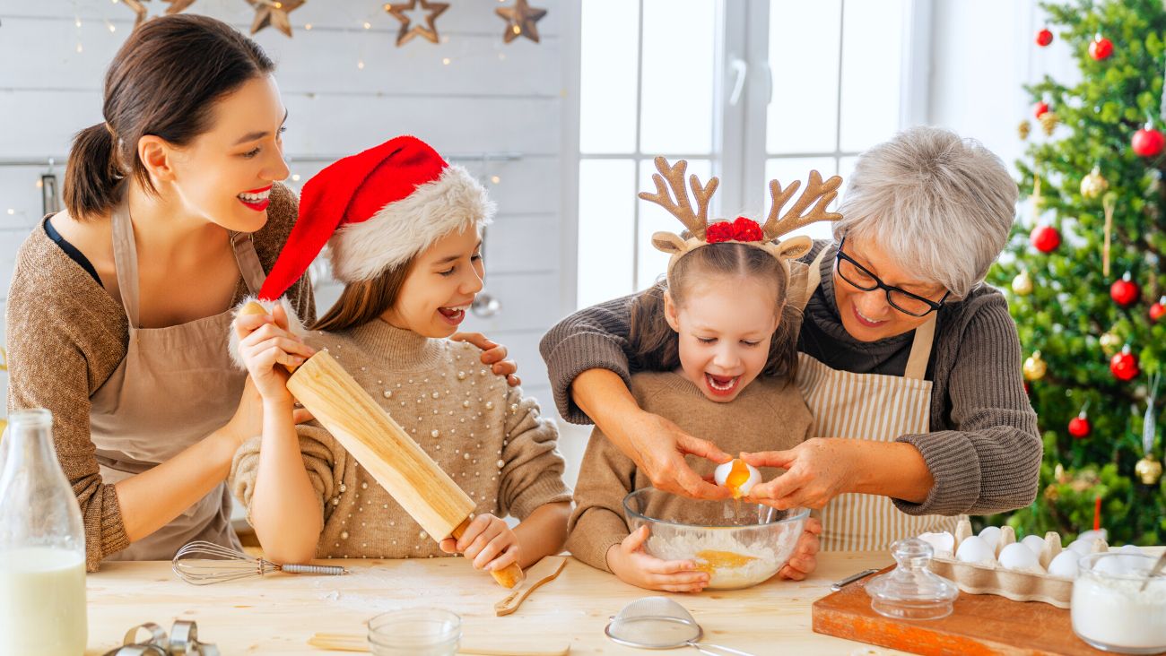 grand mère, mère et ses filles en train de préparer des biscuits de noel 